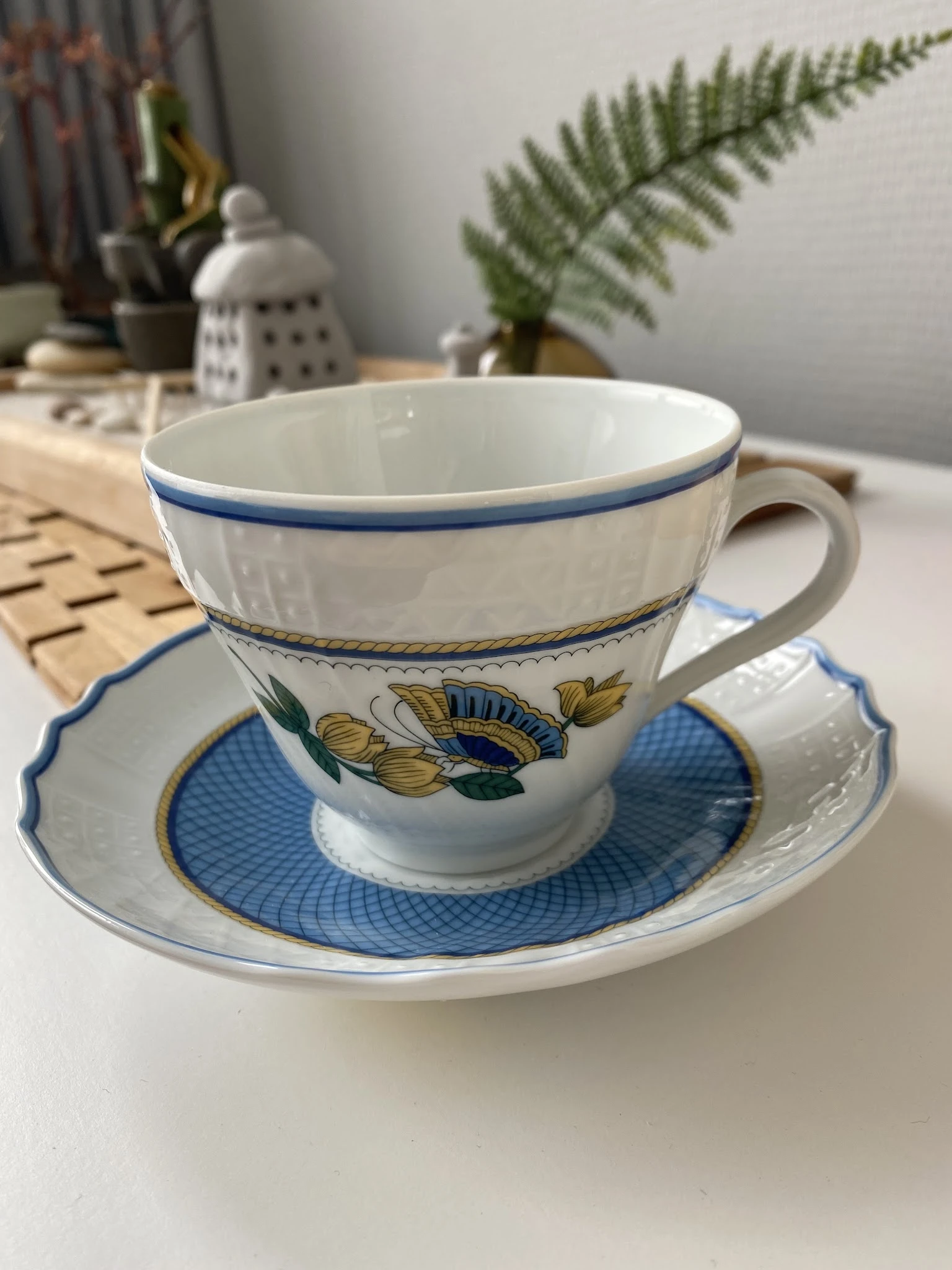 Blauw-wit porselein theekopje met schotel met bloemmotief