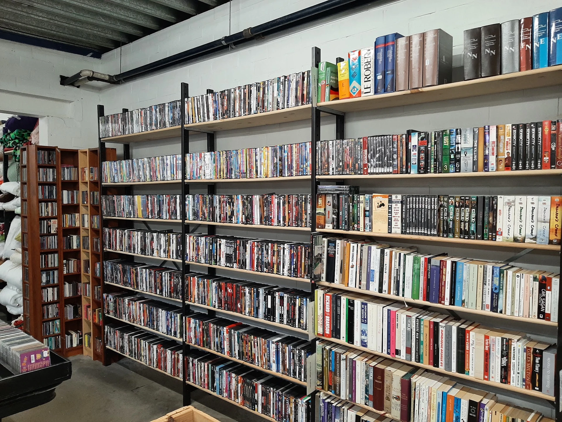 Uitgebreide verzameling dvd's en blu-rays op houten stellingen in de winkel