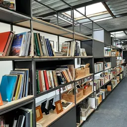 Stellingen vol met boeken en andere artikelen in een kringloopwinkel