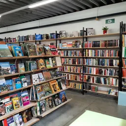 Boekenrekken en boekenstalages in een kringloopwinkel met diverse titels en genres