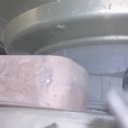 Onduidelijke close-up van wat lijkt te zijn een koelkastonderdeel of apparatuur