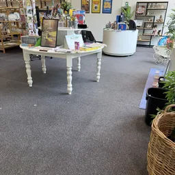 Winkelvloer met witte tafel, stellingen en diverse spullen in kringloopwinkel