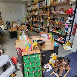 Winkelinterieur met speelgoed, poppen, voetbaltafel en andere spullen op houten meubels en stellingen