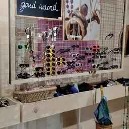 Uitgestalde zonnebrillen en accessoires op een rooster met storage eronder