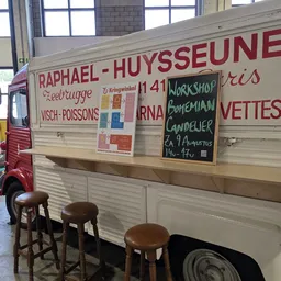 Voorkant van een food truck met menukaart 'Raphael-Huysseune' met gerechten als eebrugge visch-poissons en croquettes
