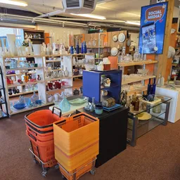 Winkelvloer met stellingen,DisplayKasten en kleurrijke kratten in een kringloopwinkel