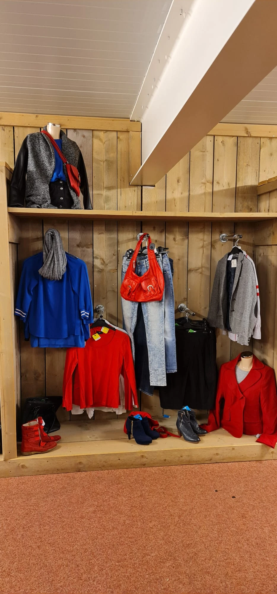 Rekken met tweedehands kleding in verschillende kleuren en stijlen
