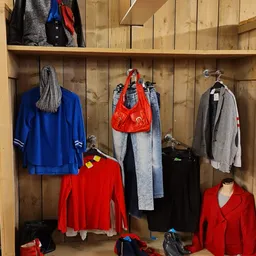 Rekken met tweedehands kleding in verschillende kleuren en stijlen