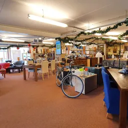 Ruim winkelbinnenland van kringloopwinkel met meubels, fietsen, kasten en diverse spullen uitgestald