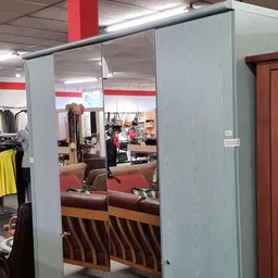 Spiegelwand in kledingafdeling met zicht op winkelrekken met tweedehands kleding