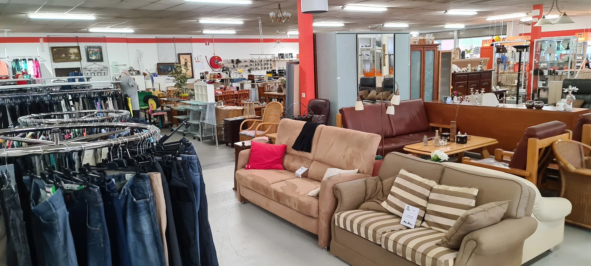 Bruine en beige banken en fauteuils met kussens uitgestald in de kringloopwinkel