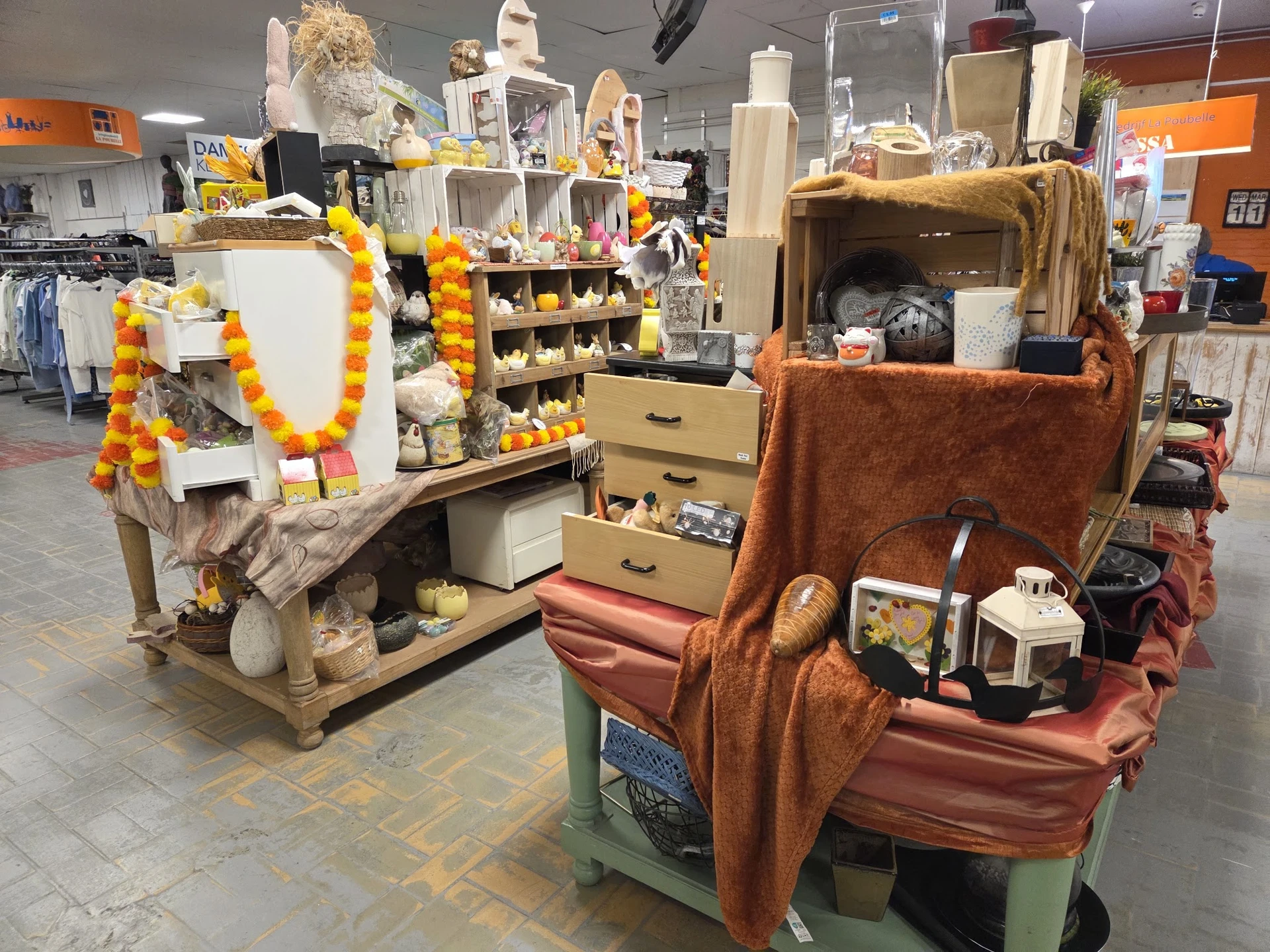 Uitgestalde huishoudelijke artikelen en decoraties op verschillende stellingen en kasten in de winkel