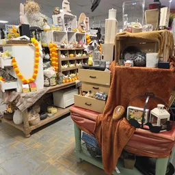 Uitgestalde huishoudelijke artikelen en decoraties op verschillende stellingen en kasten in de winkel