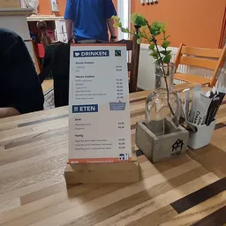 Menukaart met dranken- en eetkeuze op houten tafel met bloemen en serviesgoed