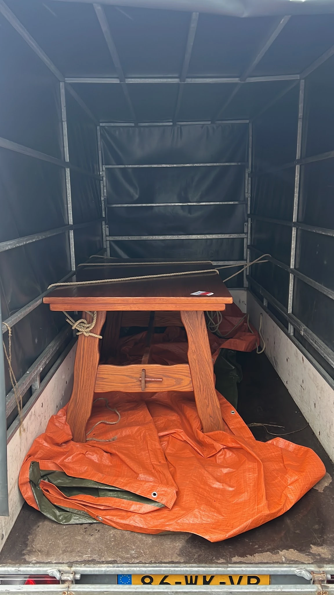 Houten tafeltje met oranje en rode items in een transportvoertuig