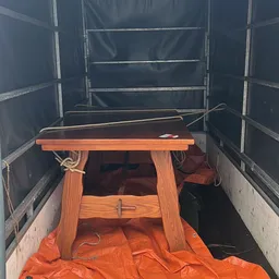 Houten tafeltje met oranje en rode items in een transportvoertuig