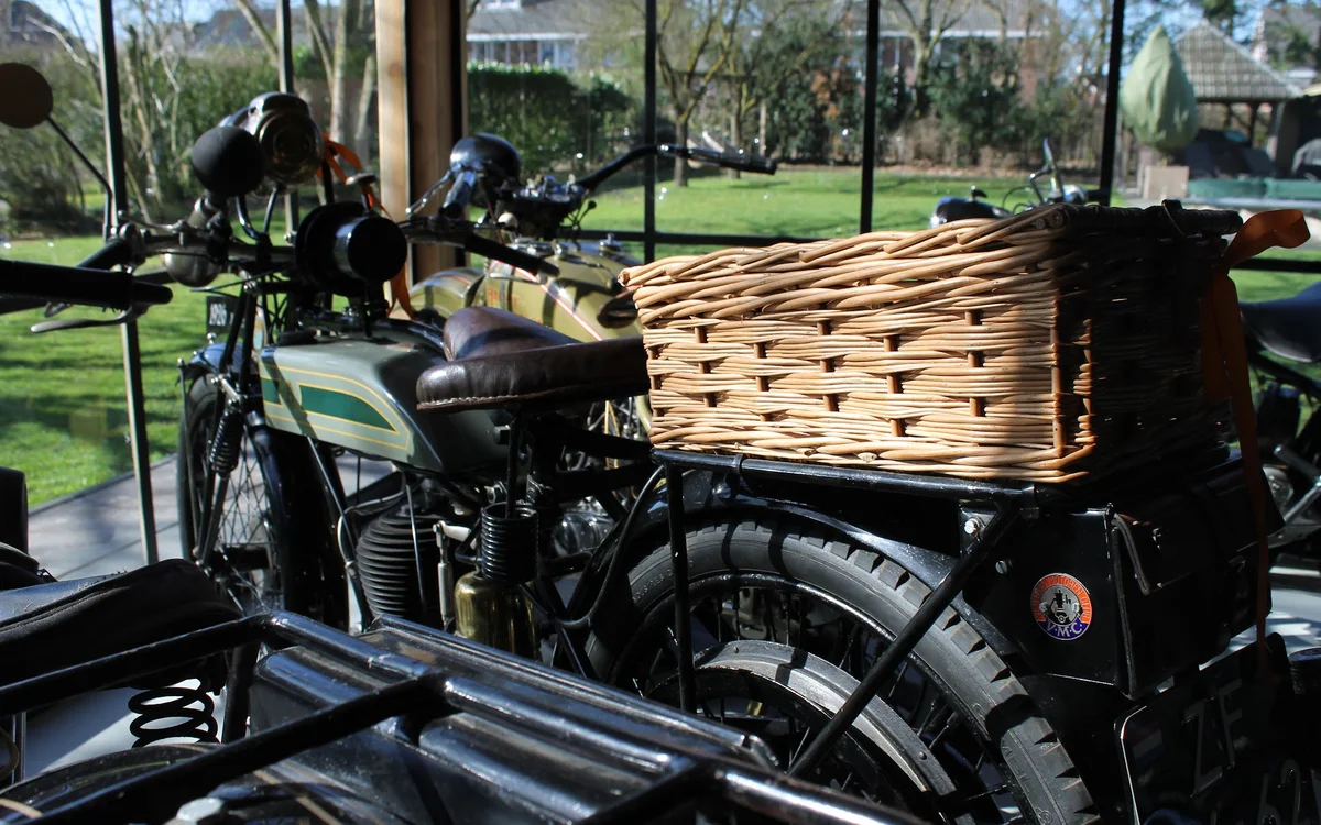 Vintage motorfiets met zijspan en rieten mand op uitstalling