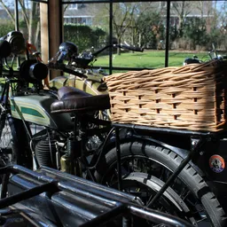 Vintage motorfiets met zijspan en rieten mand op uitstalling