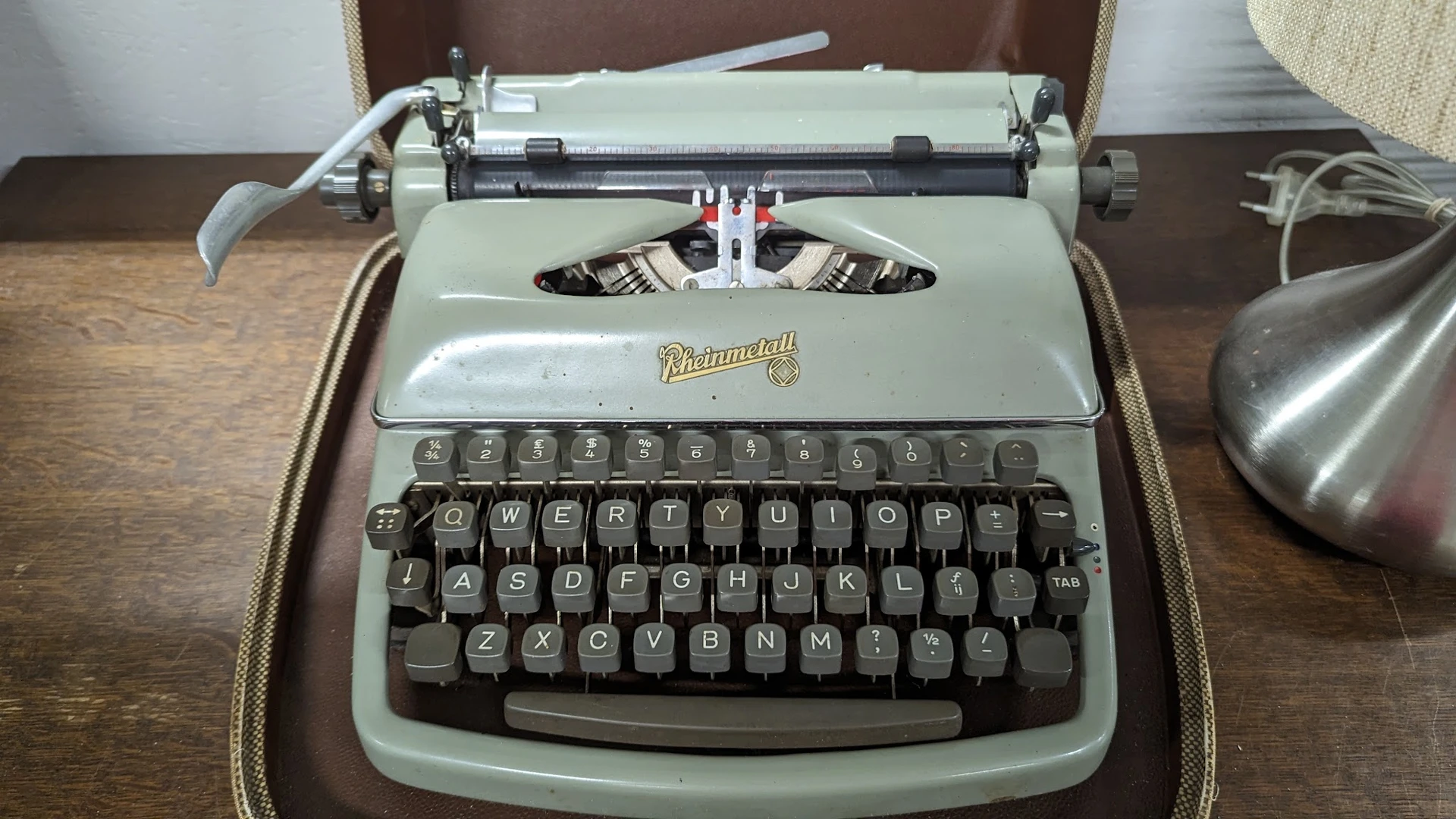 Vintage Underwood typemachine in lichtgroen met koffer, close-up van bovenkant