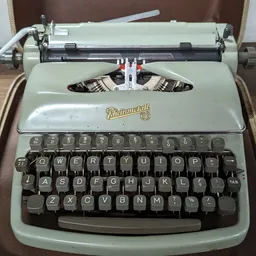 Vintage Underwood typemachine in lichtgroen met koffer, close-up van bovenkant