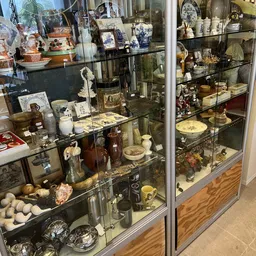 Glazen vitrinekasten met uitgestalde verzamelobjecten, porselein, beeldjes en decoratieve items