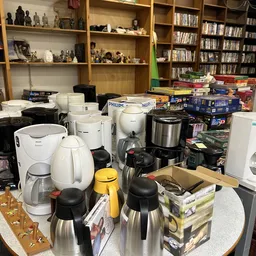Verzameling tweedehands koffiezetapparaten en huishoudelijke apparaten op een tafel