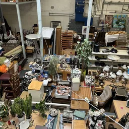 Onoverzichtelijk interieur van kringloopwinkel met diverse meubels, huishoudartikelen en spullen door elkaar