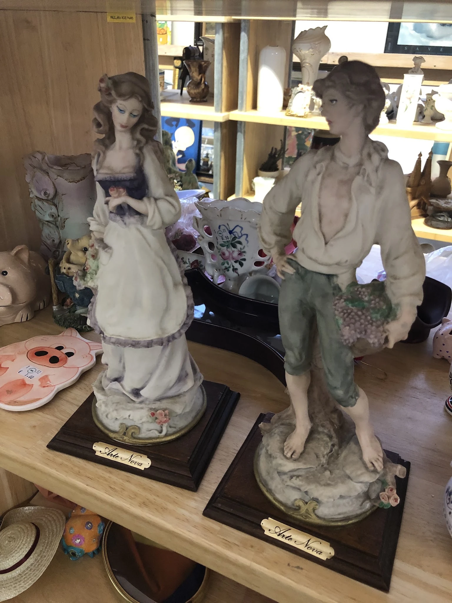 Decoratieve beelden en keramische figuren op display in kringloopwinkel