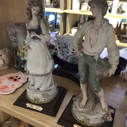 Decoratieve beelden en keramische figuren op display in kringloopwinkel