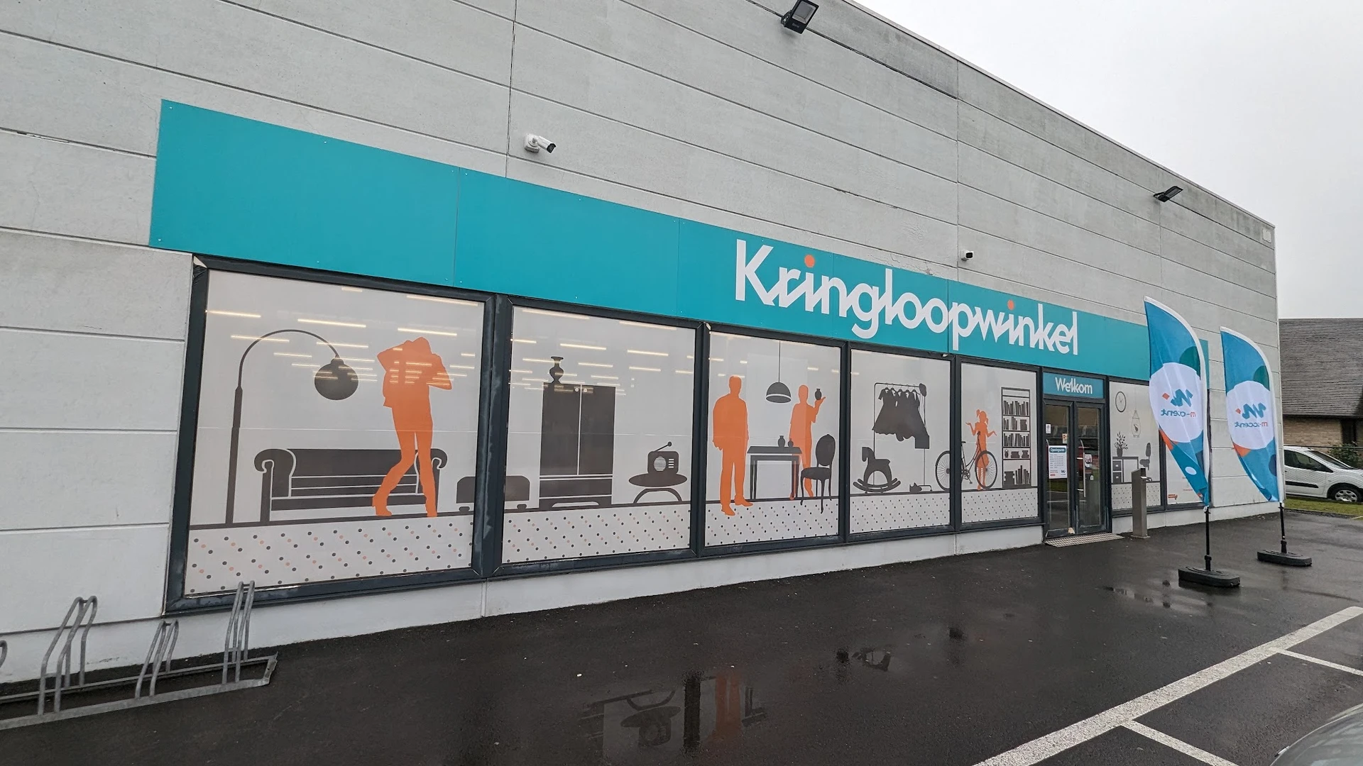 Winkelgevel met turquoise bovenbalk en grote ramen, met illustraties van huishoudelijke artikelen en meubilair