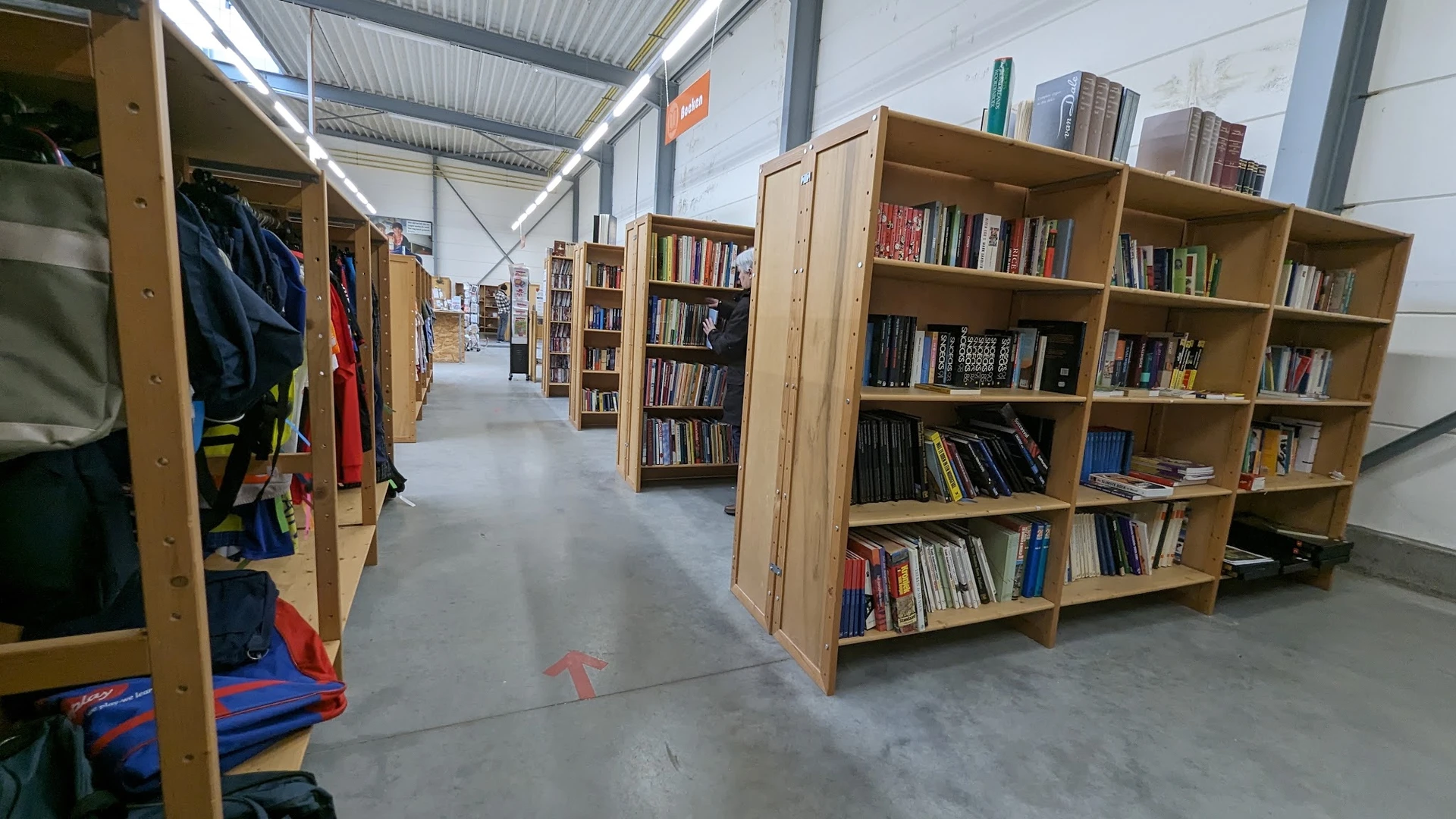 Winkelvloer met houten boekenkasten gevuld met boeken en tweedehands spullen