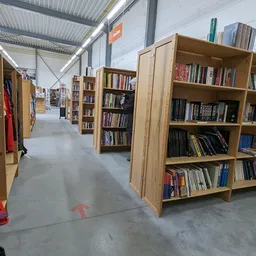 Winkelvloer met houten boekenkasten gevuld met boeken en tweedehands spullen