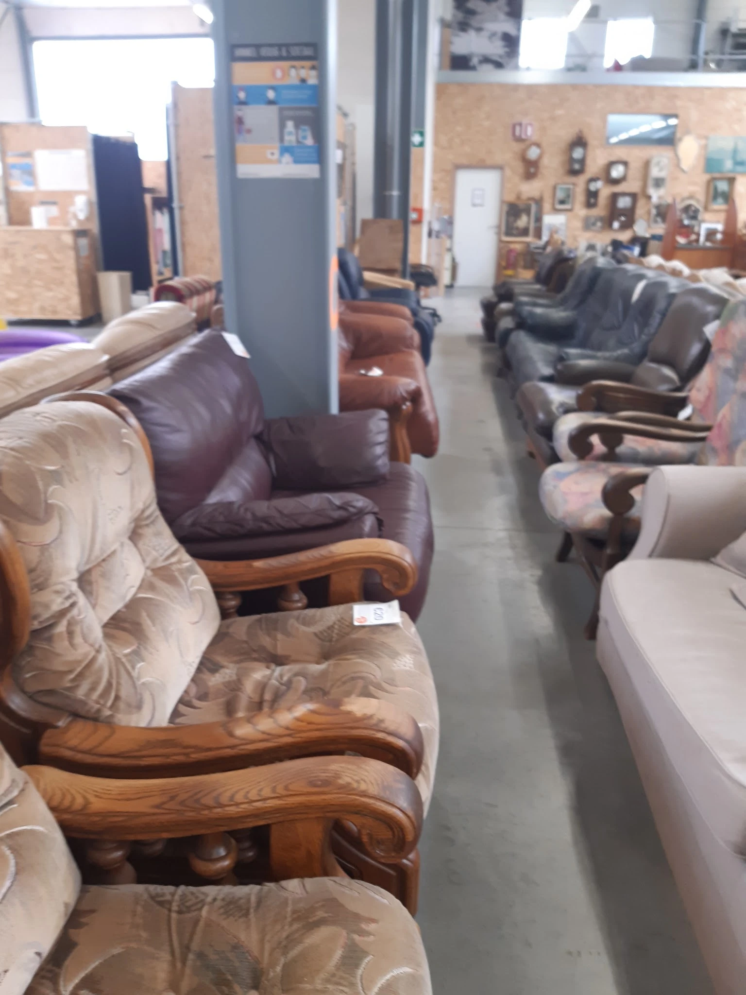 Rij met verschillende fauteuils en stoelen in bruine, grijze en beige tinten uitgestald in de winkel
