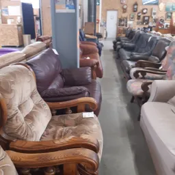 Rij met verschillende fauteuils en stoelen in bruine, grijze en beige tinten uitgestald in de winkel