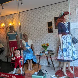 Vintage winkelinterieur met etalagepoppen in retrostijl kleding, bloemen in vaas en decoratie