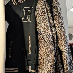Rekken met tweedehands kleding in zwart en luipaardprint