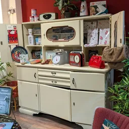 Vintage kasten en wandmeubels met decoratieve spullen, klokken, bordjes en huishoudelijke artikelen.