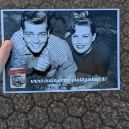 Vintage zwart-witfoto van een man en vrouw uit de jaren 1950, beiden glimlachend naar de camera