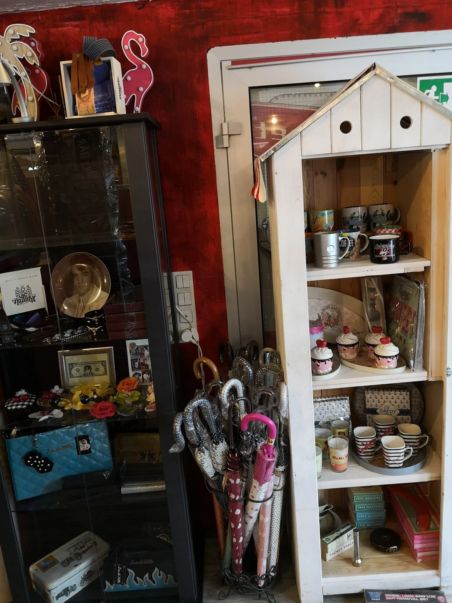 Vintage winkelkast met verschillende serviesgoed, decoratieve items en keramiek op houten planken
