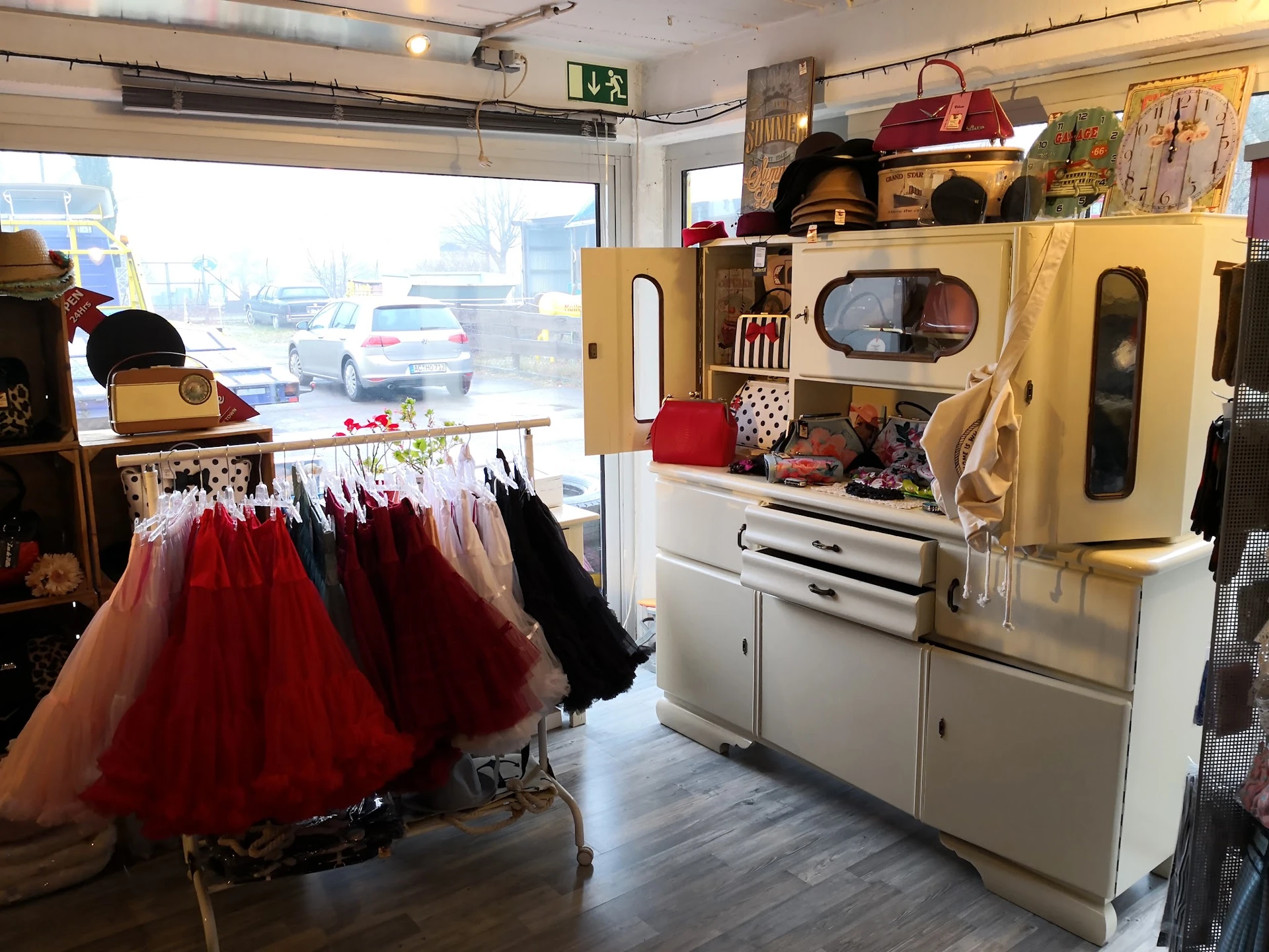 Vintage winkelinterieur met rode tutus aan rek, vintage fornuis en handtassen op display