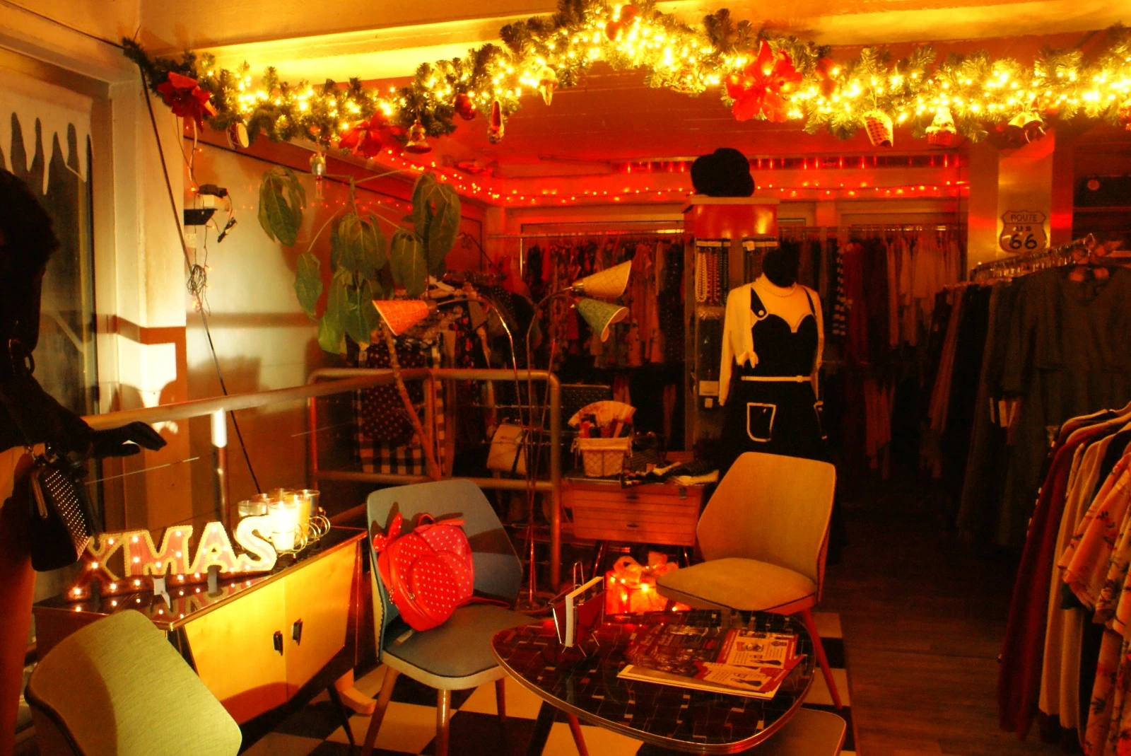 Vintage winkelinterieur met kerstversiering, verlichte guirlandes, kledingrekken en decoratieve items