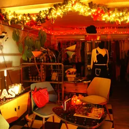Vintage winkelinterieur met kerstversiering, verlichte guirlandes, kledingrekken en decoratieve items
