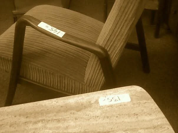 Tweedehands houten stoelen met gestreept bekleding, één stoel scherp zichtbaar op voorgrond
