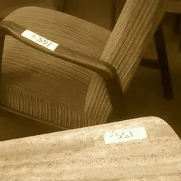 Tweedehands houten stoelen met gestreept bekleding, één stoel scherp zichtbaar op voorgrond