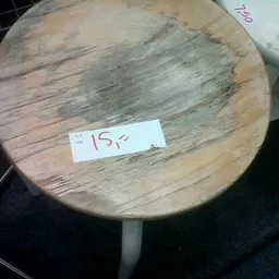 Ronde houten tafel met prijskaartje waarop '15?' staat geschreven