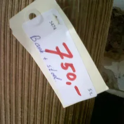 Prijskaartje met handgeschreven bedrag van 4,50 euro op houten ondergrond
