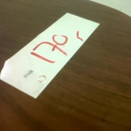 Wit papier met handgeschreven rode cijfers '120' en '5'
