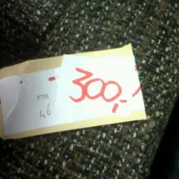 Prijssticker met '300' in rode letters op tekstureerde achtergrond