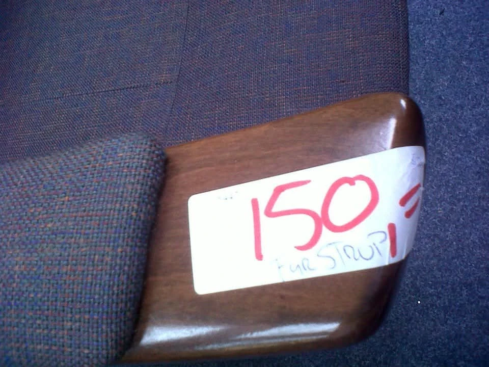 Houten armleun of meubeldeel met prijssticker waarop '150' en 'UITSTROOI' geschreven staat