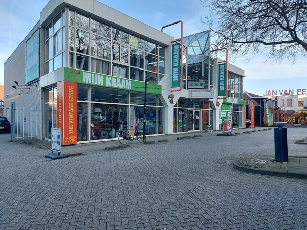 Gevel van kringloopwinkel Mijn Kraam met groene letters, winkelramen en glazen bovenbouw aan Noorder Passage in Emmen